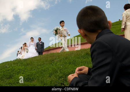 Kazakh brides and grooms during a simultaneously mass wedding ceremony in Arai park in Nur-Sultan or Nursultan called Astana until March 2019 capital of Kazakhstan Stock Photo