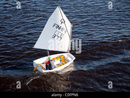 Young boy sailing alone with a small sailing boat , Finland Stock Photo