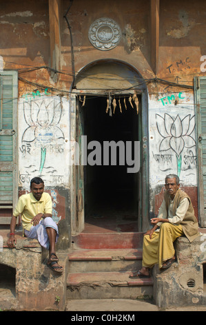 Men sitting on the steps of a building in the backstreets of Kumartuli, Kolkata (Calcutta), West Bengal, India Stock Photo