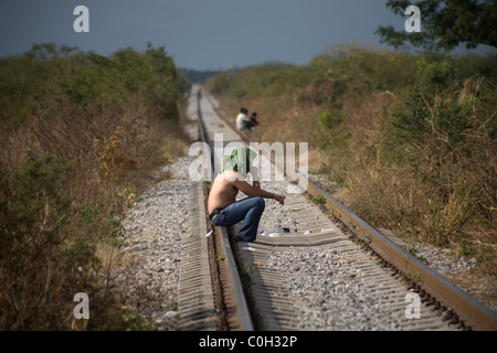 A Central American migrant waits along the railroad to jump a train, in Ixtepec, Oaxaca state, Mexico, January 9, 2011. Stock Photo