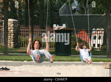 Chris Cornell and his daughter Toni playing on the swings as the musician spent some quality time with his two young children Stock Photo