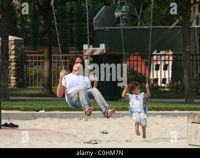 Chris Cornell and his daughter Toni playing on the swings as the musician spent some quality time with his two young children Stock Photo