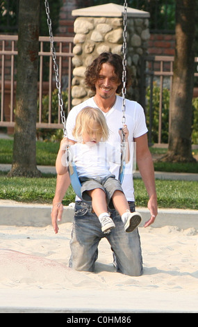 Chris Cornell and his son Christopher playing on the swings as the musician spent some quality time with his two young children Stock Photo