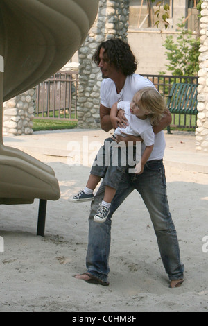 Chris Cornell and his son Christopher playing on the slide as the musician spent some quality time with his two young children Stock Photo
