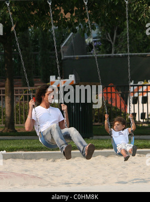 Chris Cornell and his daughter Toni playing on the swings as the musician spent some quality time with his two young children Stock Photo