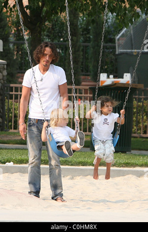 Chris Cornell, his son Christopher and daughter Toni playing on the swings as the musician spent some quality time with his two Stock Photo