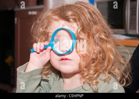 Young Girl Looking Through A Magnifying Glass Stock Photo
