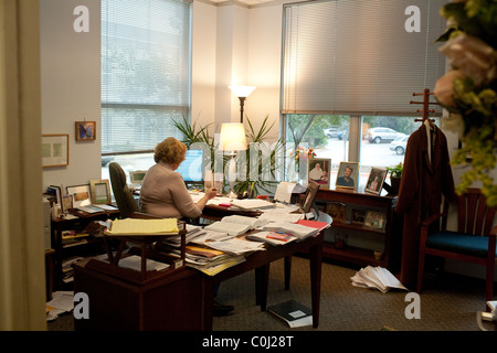 Busy female attorney works in her office surrounded by piles of paperwork in Austin Texas Stock Photo