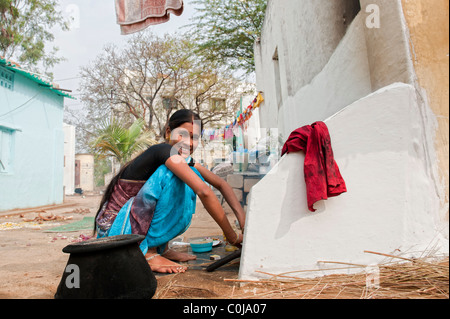 Young south indian mother tending a fire outside her home. Andhra Pradesh, India Stock Photo