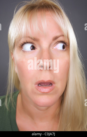 Shocked Blond Woman with Funny Face against a Grey Background Stock ...