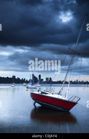 Yacht moored at Matilda Bay on the Swan River as storm clouds gather over Perth, Western Australia Stock Photo