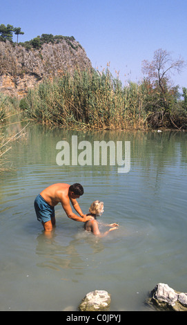 Tourists in Turkey enjoying the mud in the thermal springs near Dalyan.  There are baths at Sultaniye but many like the natural. Stock Photo