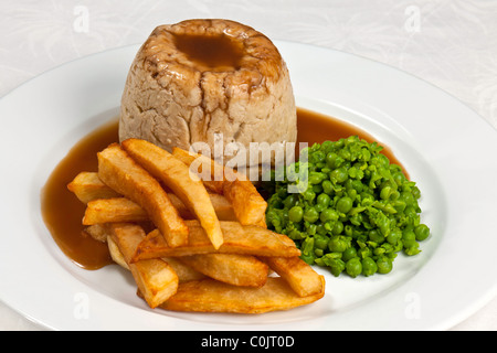 Chef's Presentation dish - Steak and kidney pudding; hand cut chips; peas. Stock Photo