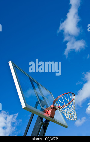 Outdoor basketball hoop with blue sky and clouds Stock Photo