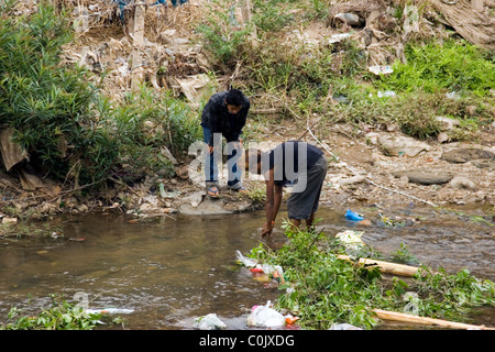 Two Burmese teenage boys are bathing in a dirty and polluted river in Tachilek, Burma (Myanmar). Stock Photo