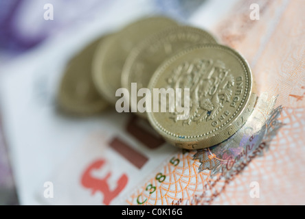 Ten pound sterling notes and one pound coins are set up for a photograph Stock Photo