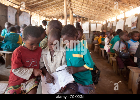 Children learn in a grass hut school in Dedza, Malawi, Southern Africa. Stock Photo