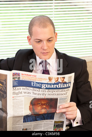 man reading The guardian newspaper in UK Stock Photo