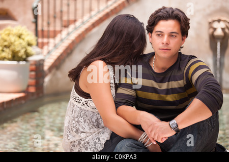 Hispanic Couple During A Serious Moment at a Fountain. Stock Photo