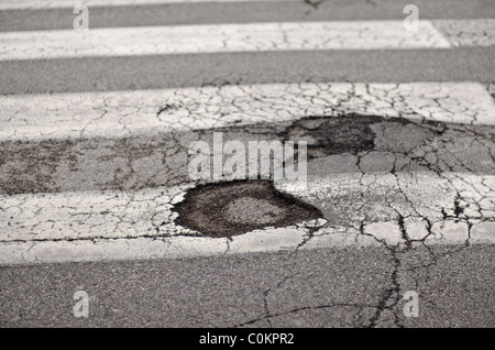 Hole in road on zebra crossing Stock Photo