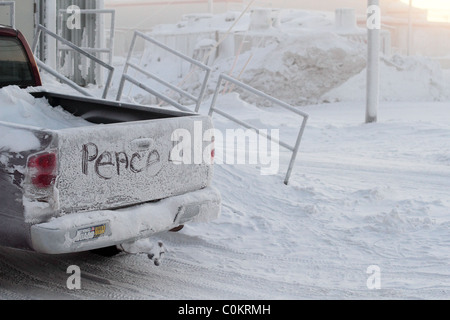 The word peace written across back of pickup tailgate in the ice in Barrow, AK in Arctic Circle with National Guard sticker. Stock Photo