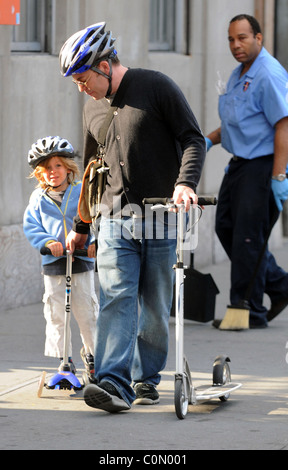 Matthew Broderick takes his son James to school. The pair ride scooters along the sidewalk wearing crash helmets for safety New Stock Photo