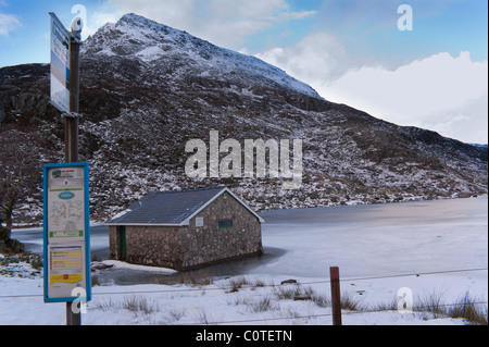 Bus stop at Ogwen Cottage Snowdonia looking onto  a frozen Llyn Ogwen & Pen yr Ole Wen. Stock Photo