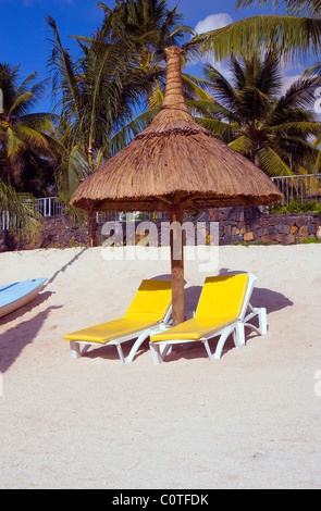 Mauritius Beach holiday sun-loungers and straw sun-shade Stock Photo