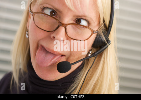 Goofy businesswoman talks on her phone headset. Stock Photo