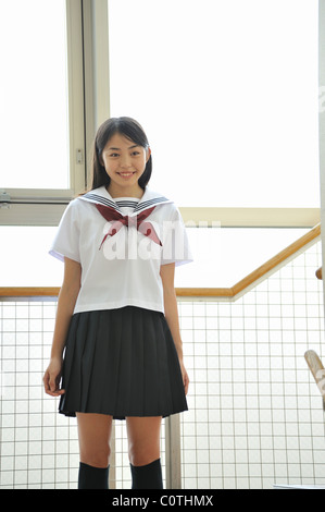 High school girl standing by window Stock Photo - Alamy