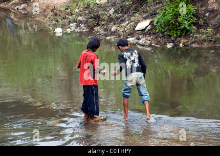 Two Burmese teenage boys are bathing in a dirty and polluted river in Tachilek, Burma (Myanmar). Stock Photo