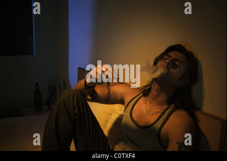 Man smoking on the bed Stock Photo