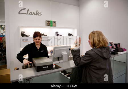 A woman buying shoes at the checkout, Clarks shoe shop, Bromley, Kent UK Stock Photo
