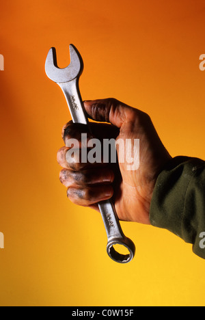 mechanic with oily hand holding spanner Stock Photo