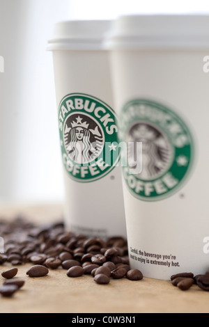 Two Starbucks to go coffee cups with beans Stock Photo