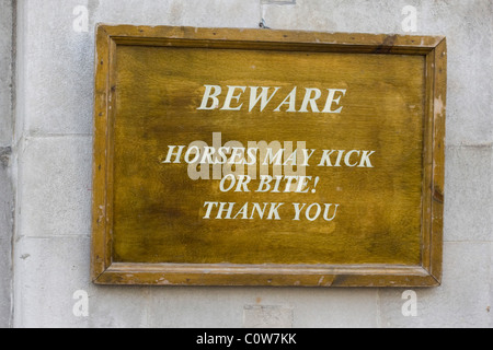 A Wooden Sign Warning the public that Horses kick and Bite at Horse guards Parade London England Stock Photo