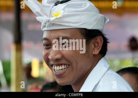 Smiling Balinese man wearing the traditional udeng head dress at a temple festival in Padang Bai in eastern Bali Indonesia Stock Photo