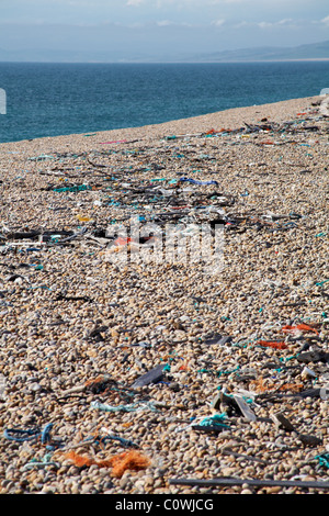 Jetsam and flotsam washed up on the pebbled bank at Chesil beach, Dorset UK in August - ocean pollution concept Stock Photo