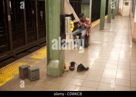 Vagrant man in New York subway station by a phonebox Stock Photo