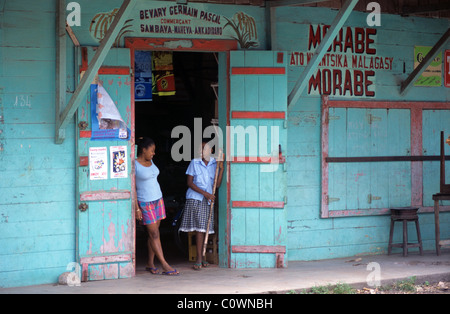 Malagasy Girls at Entrance to General Store, Corner Store or Village Shop on Main Street, Sambava, Madagascar Stock Photo