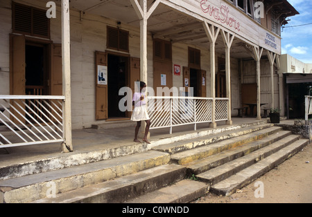 Malagasy Girl Outside a Timber-Frame or Wooden General Store or Convenience Shop on the Main Street of Sambava, Madagascar Stock Photo