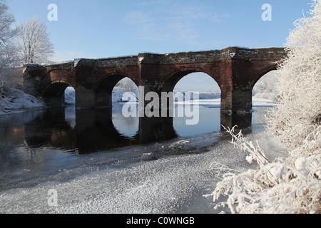 Village of Farndon, England. Picturesque winter view of the Grade 1 Listed 14th century medieval Holt Bridge over the River Dee. Stock Photo
