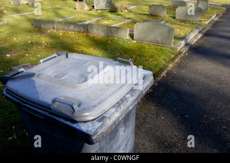 grave yard with head stones with Wheelie Bins say 'NO HOT ASHES Stock Photo