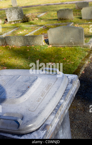 grave yard with head stones with wheelie Bins bin say 'NO HOT ASHES Stock Photo