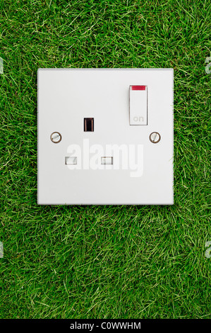 Electrical Socket on Grass. Green Energy Concept. Stock Photo