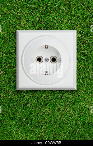 Electrical Socket on Grass. Green Energy Concept. Stock Photo