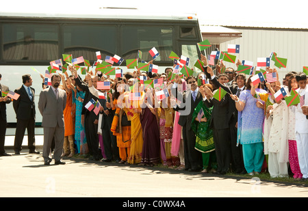 Ismaili Muslims wave small Ismaili and Texas flags while greeting the Aga Khan during a ceremony at the airport in Austin Texas Stock Photo