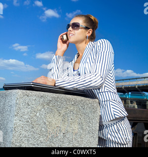 A young and attractive businesswoman using her mobile phone Stock Photo