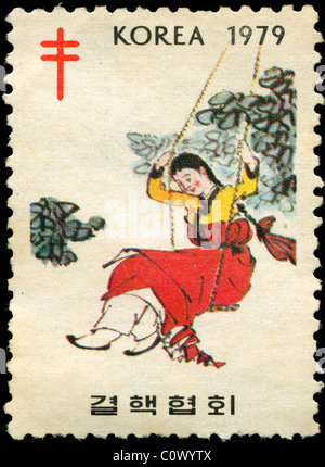 Old postage stamp from Korea with picture of a girl in a swing Stock Photo