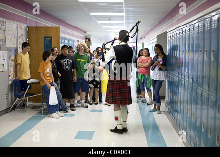 Male bagpipe player in kilt demonstrates the instrument in the hallway at Park Crest Middle School during Diversity Day Stock Photo